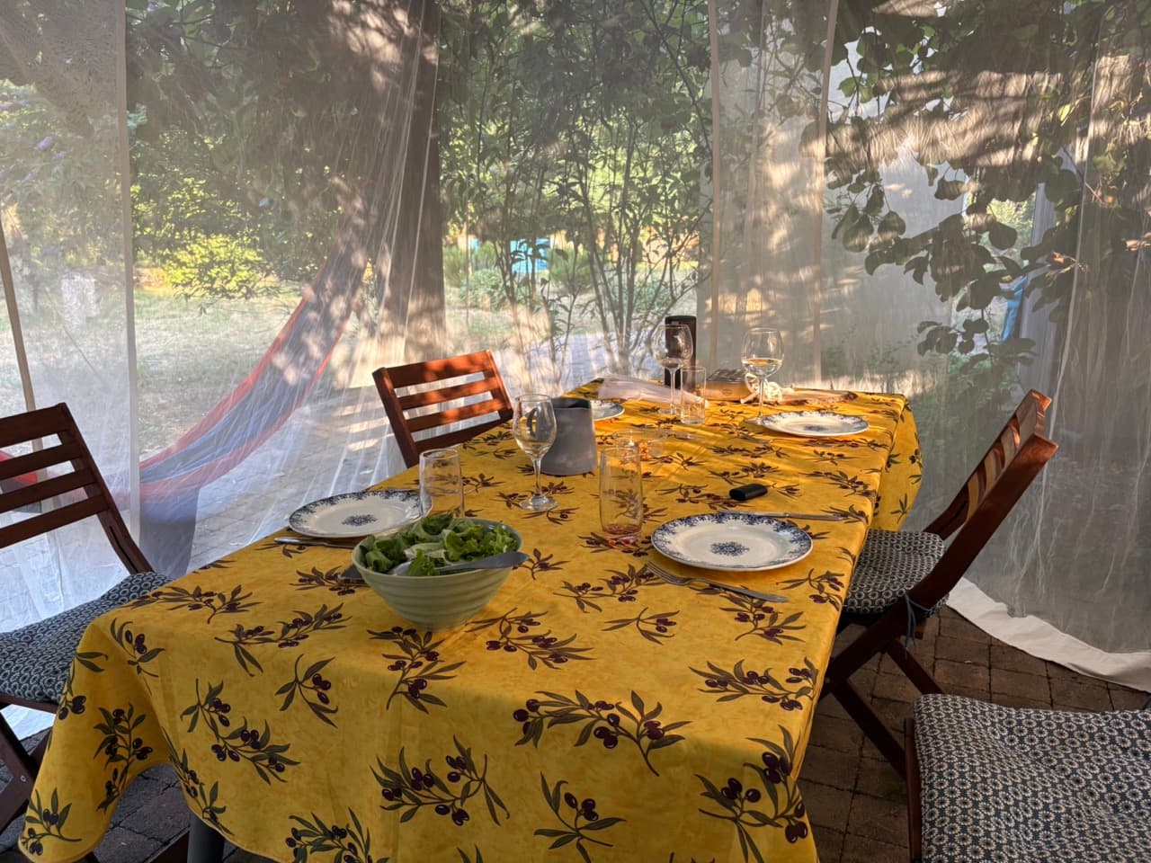 Dining table set with yellow tablecloth under garden pergola