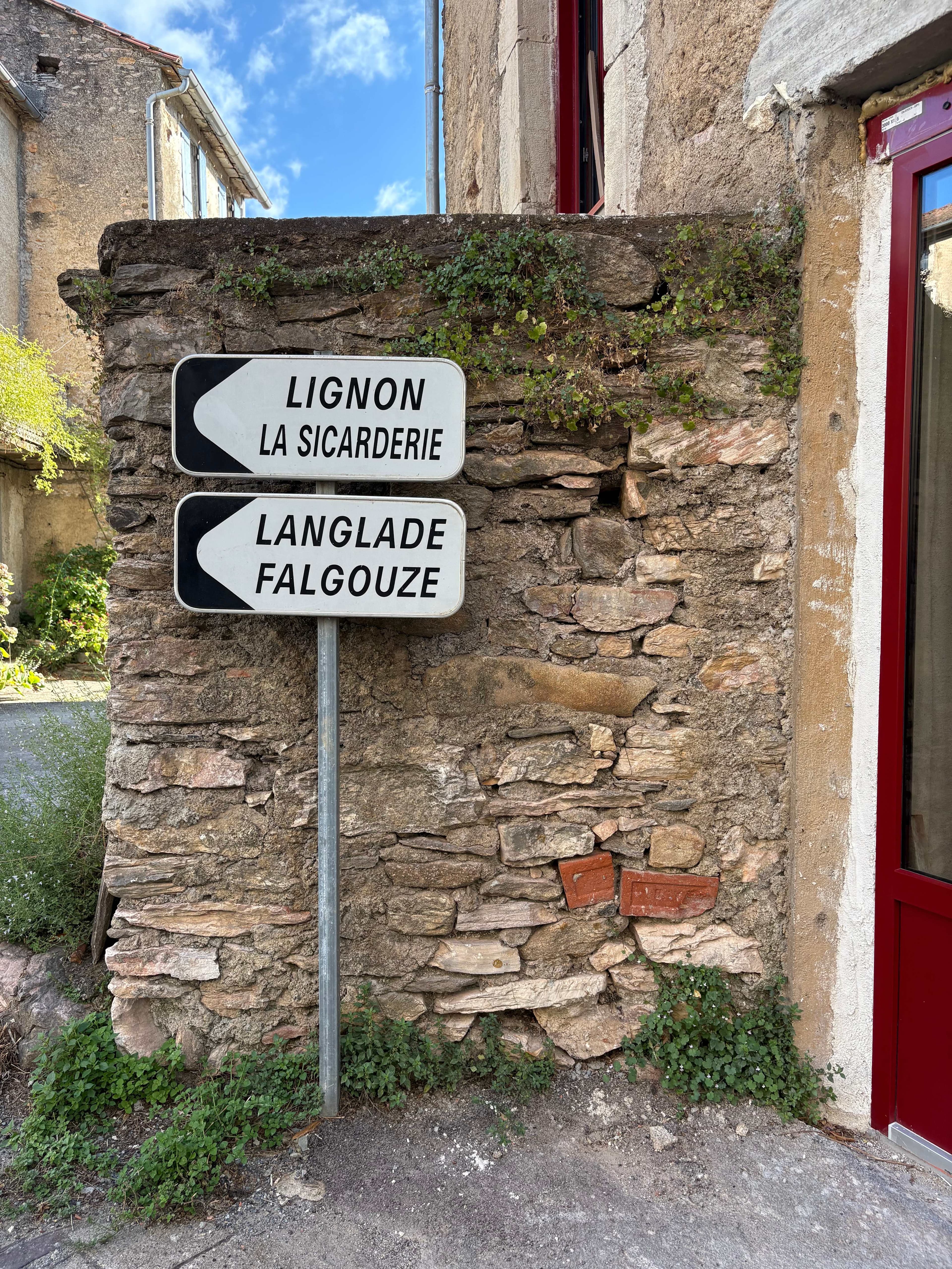 Local road sign showing directions to Lignon and Langlade