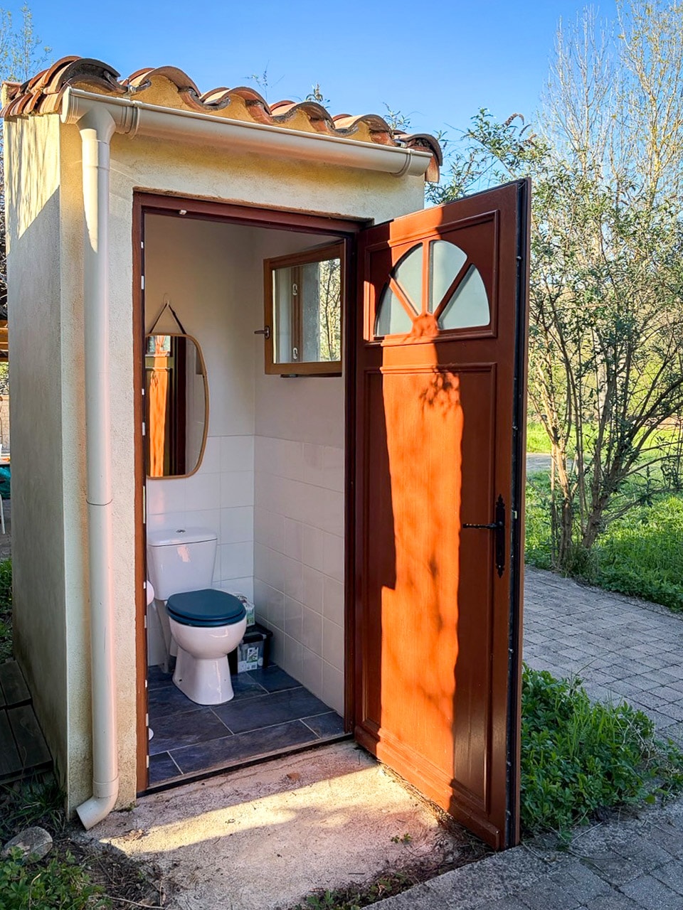 Outdoor toilet building with open wooden door