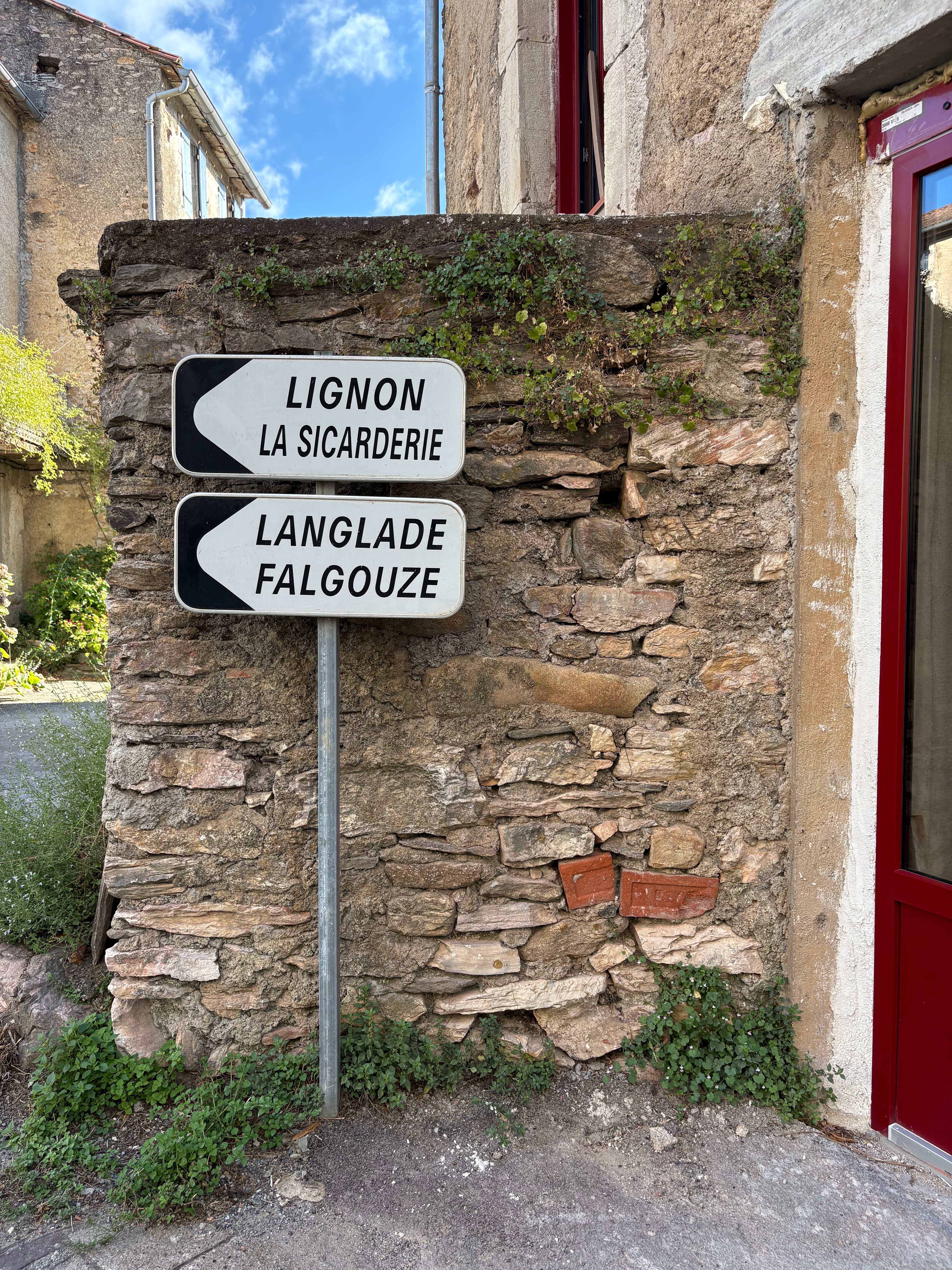 Local road sign showing directions to Lignon and Langlade