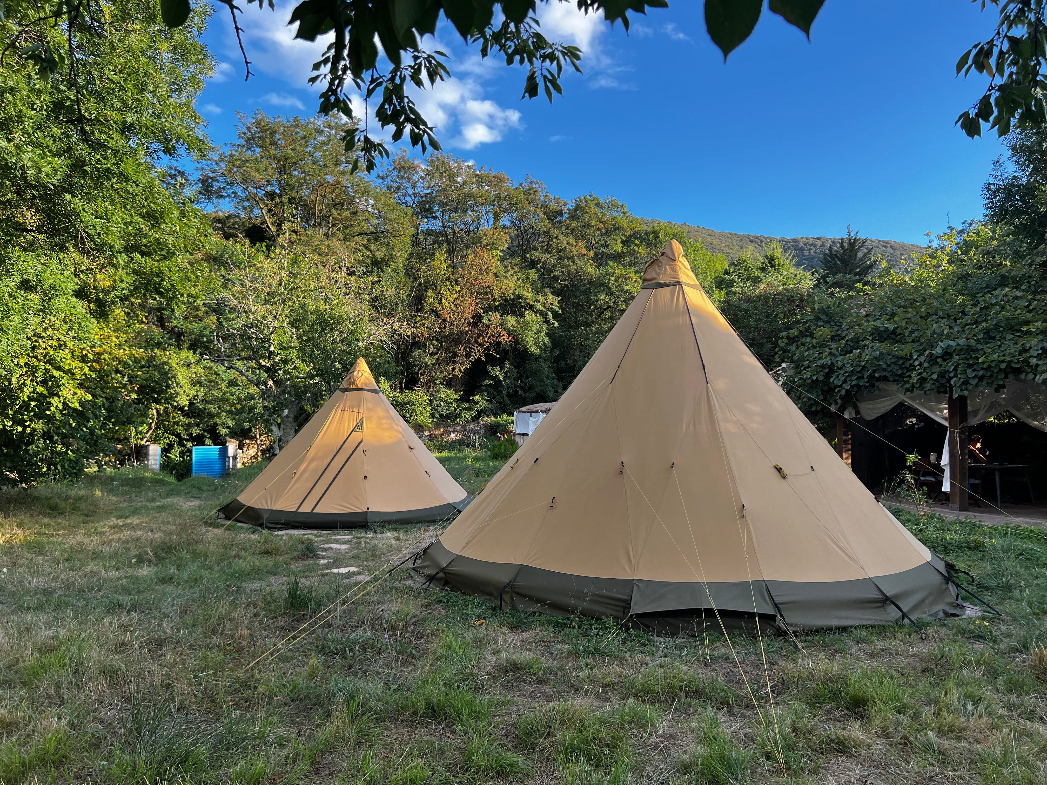 Tipis in natural landscape with mountains